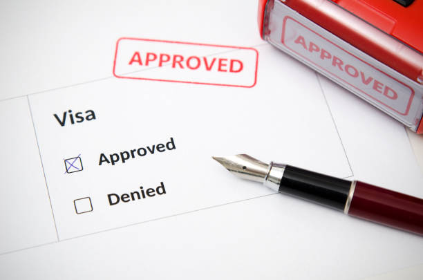 Visa and approved stamp on a document form. Immigration and travel concept