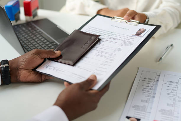 Close-up of man giving documents to specialist to get visa